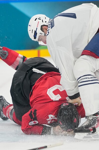 France's Pierre Crinon (7) fights with Canada's Tom Wilson (43) during a preliminary round game of men's ice hockey between Canada and France at the 2026 Winter Olympics, in Milan, Italy, Sunday, Feb. 15, 2026. (AP Photo/Hassan Ammar)