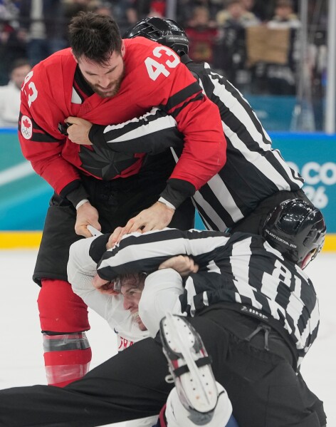 France's Pierre Crinon (7) and Canada's Tom Wilson (43) fight in the third period during a preliminary round game of men's ice hockey between Canada and France at the 2026 Winter Olympics, in Milan, Italy, Sunday, Feb. 15, 2026. (AP Photo/Hassan Ammar)