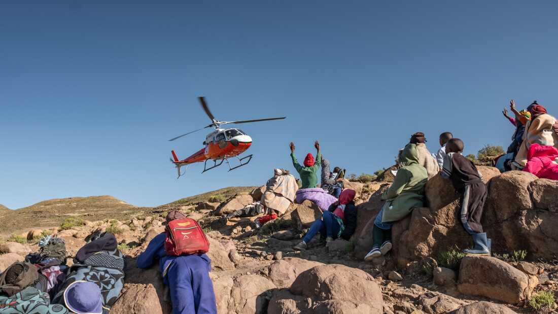 Residents of the isolated village of Mphooko wave as a team from the Lesotho Flying Doctor Services departs after a day treating patients in the village. Mphooko is inaccessible by road, and relies on the LFDS for basic medical care.