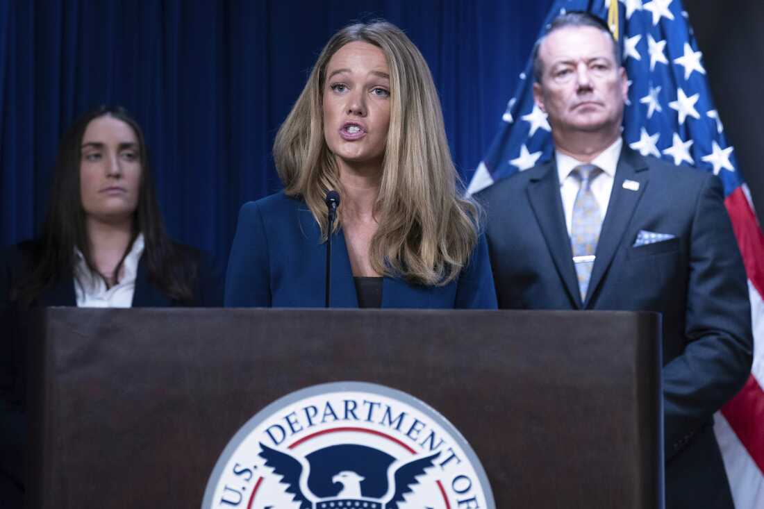 Standing behind a lectern with a microphone attached to it, Tricia McLaughlin, the assistant secretary for public affairs at the Department of Homeland Security, speaks during a news conference at the headquarters of Immigration and Customs Enforcement in May 2025.