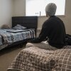 Jefferson, a refugee residing in the Parkview Apartments community in Riverdale, Maryland sits in his bedroom that he shares with his roommate on Feb. 27, 2025.