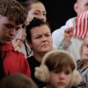Newly arrived South Africans listen to representatives from Homeland Security and the State Department deliver welcome statements in a hangar at Atlantic Aviation Dulles near Washington Dulles International Airport on May 12, 2025 in Dulles, Va.