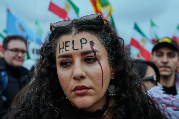 A woman participates in a demonstration in support of Iran's exiled Crown Prince Reza Pahlavi during the Munich Security Conference in Munich, Germany, Feb. 14, 2026. (AP Photo/Ebrahim Noroozi, File)