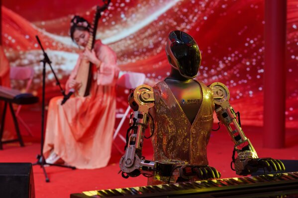 A robot accompanies a traditional music performance on stage at a Lunar New Year tech temple fair in Beijing, Feb. 19, 2026. (AP Photo/Vincent Thian, File)