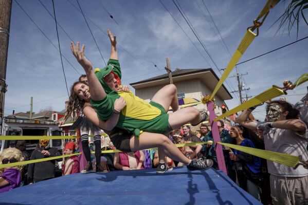People wrestle in a moving ring as they participate in the Society of Saint Anne parade through the Bywater and Marigny neighborhoods on Mardi Gras Day, Feb. 17, 2026 in New Orleans. (AP Photo/Matthew Hinton)