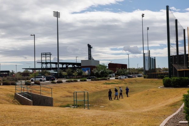 A family walks between practice fields at Cubs spring training on Feb. 18, 2026, at Sloan Park in Mesa, Ariz. (Armando L. Sanchez/Chicago Tribune)