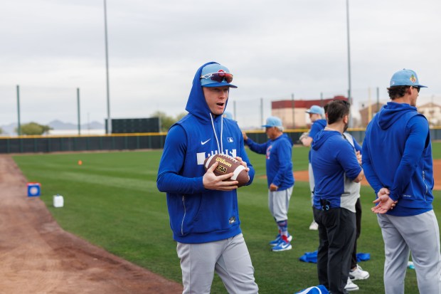 Pete Crow-Armstrong carries a football before warming up with other players during the first day of the Cubs full-squad workout at spring training at Sloan Park on Feb. 16, 2026, in Mesa, Ariz. (Armando L. Sanchez/Chicago Tribune)