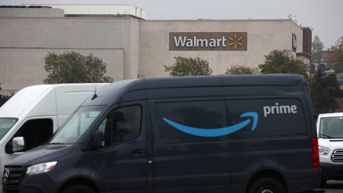 An Amazon Prime delivery van sits parked near a Walmart store in California.