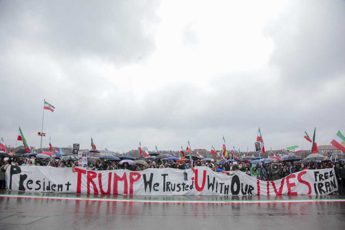 Demonstrators wave Iranian pre-1979 revolution flags during a rally in Munich on February 14. They are also holding a long banner that says: "President Trump We Trusted U With Our Lives Free Iran."