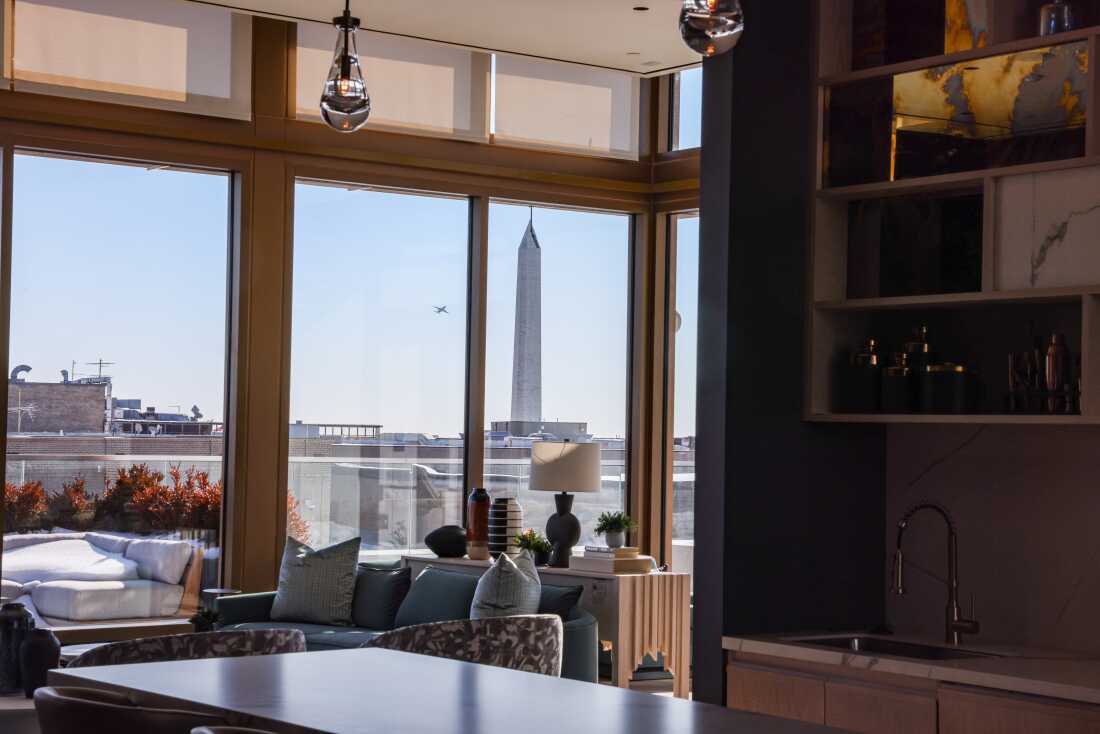 The Washington Monument is seen through the large windows of the sky lounge of the rooftop penthouse at Accolade.