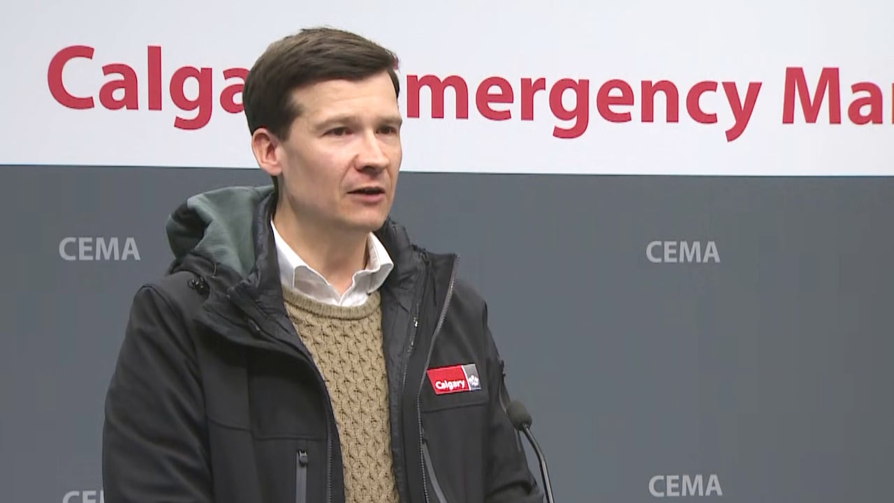 A man standing in front of a wall that says 'Calgary Emergency Management' in red.