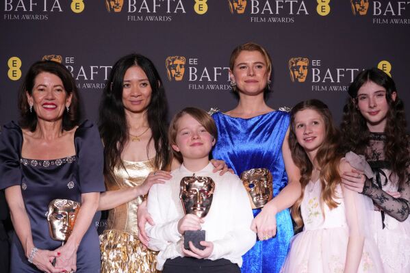 Pippa Harris, from left, Chloe Zhao, Jacobi Jupe, Jessie Buckley, Olivia Lynes, and Bodhi Rae Breathnach pose with the award for outstanding British film for 'Hamnet' at the 79th British Academy Film Awards, BAFTA's, in London, Sunday, Feb. 22, 2026. (AP Photo/Alastair Grant)