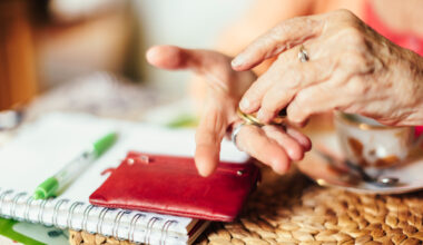Senior woman calculating finances in her kitchen.