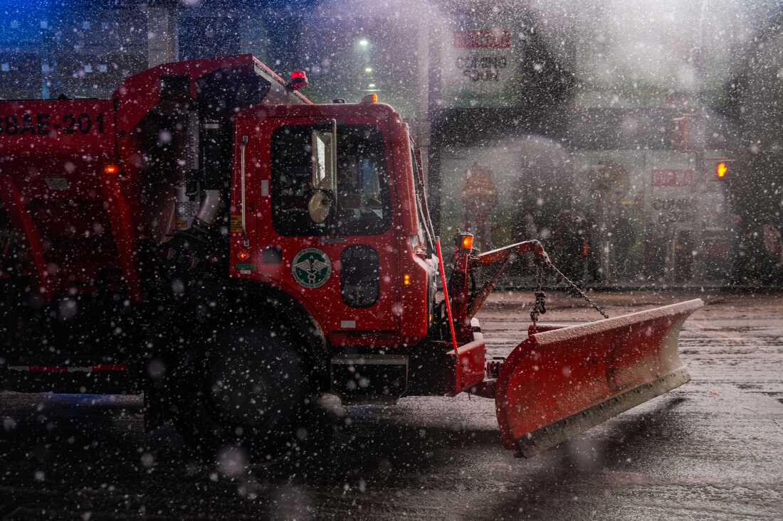 A snowplow drives down the road in Times Square on Sunday in New York City.