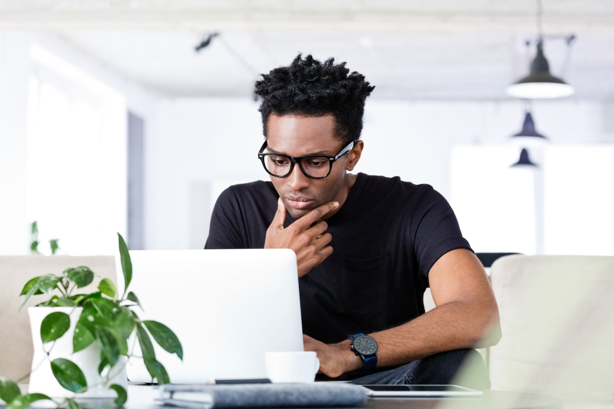 An investor working at home looks at something on a laptop.