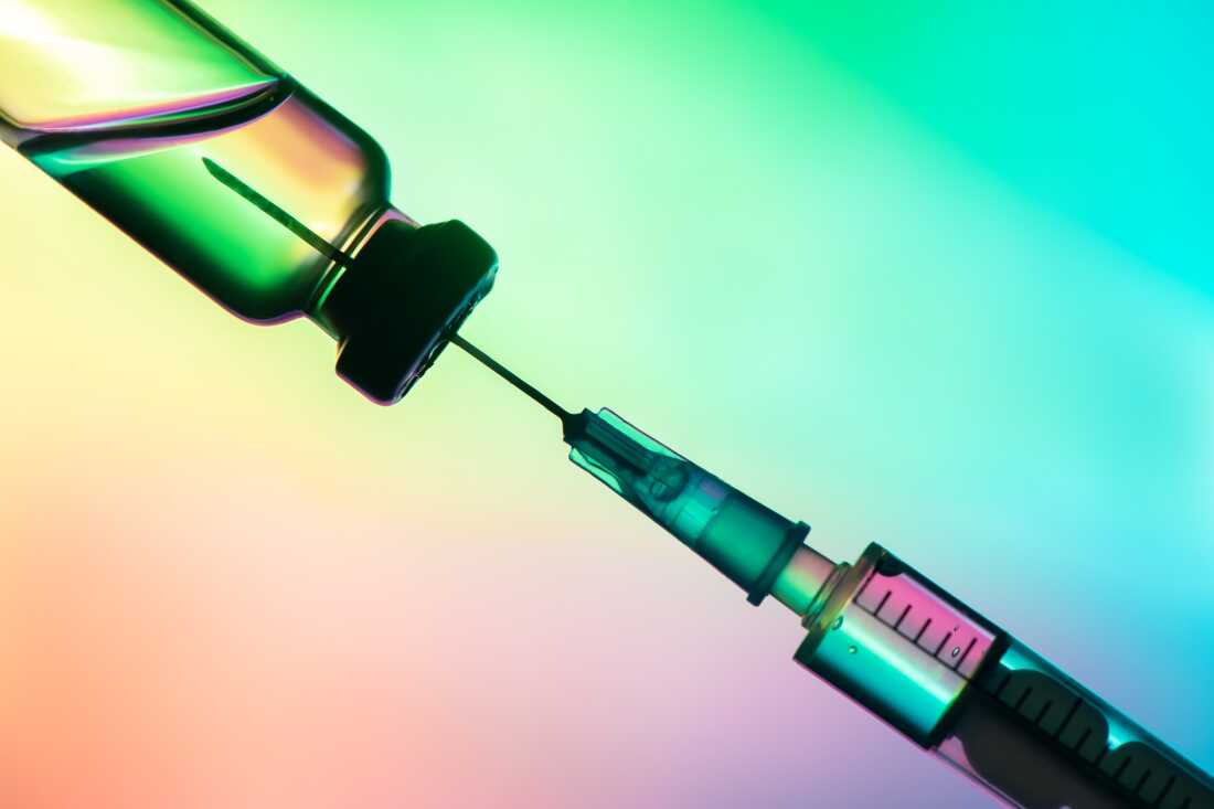 vaccination syringe and bottle on a colored background. close up, copy space