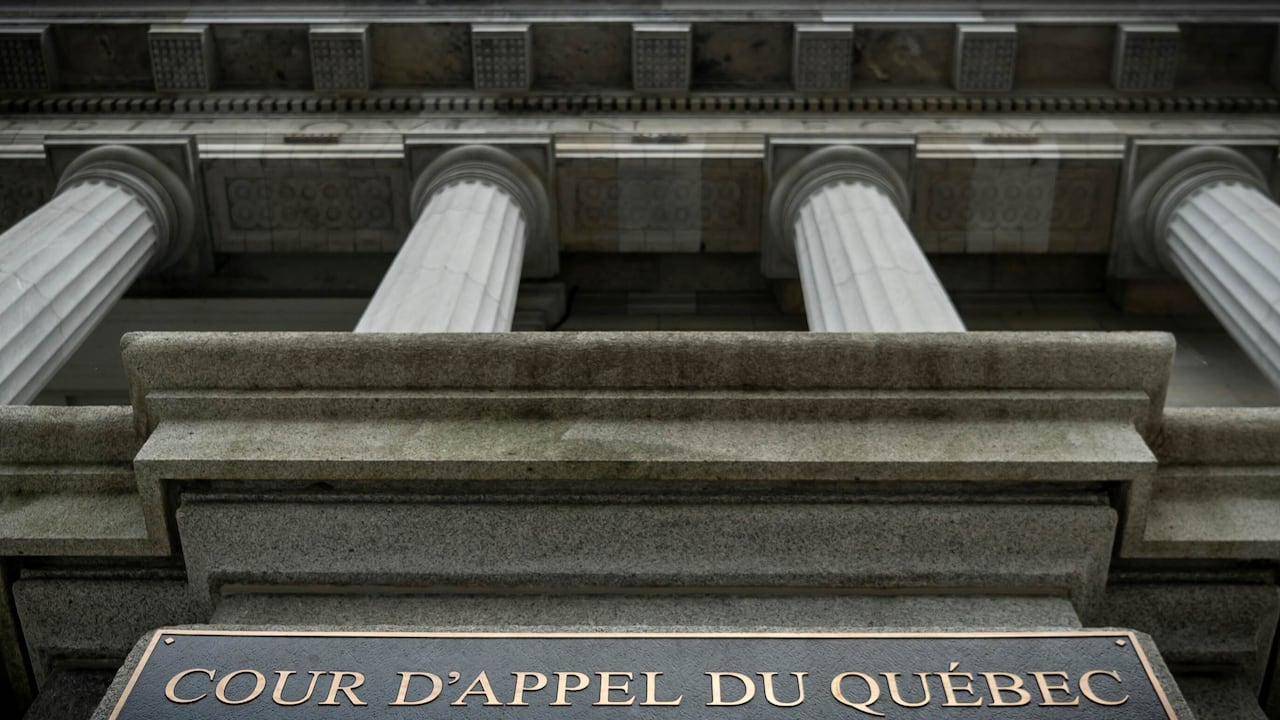 A view upward of a courthouse's pillars. Sign says Cour D'appel du Québec.