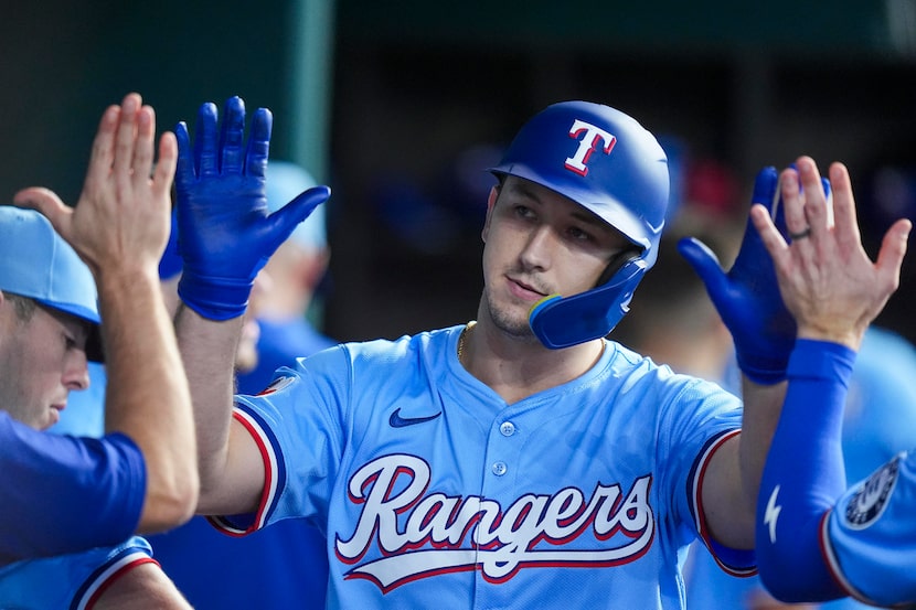 Texas Rangers left fielder Wyatt Langford celebrates in the dugout after hitting a solo home...