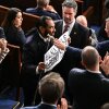 U.S. Rep. Al Green, D-Tx., exits as he holds a sign reading "Black people aren't apes" during President Trump's State of the Union address in the House Chamber of the US Capitol in Washington, DC, on February 24, 2026.