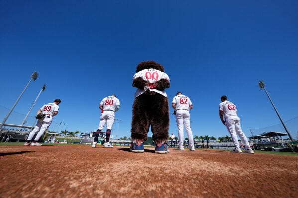 T.C., the Minnesota Twins mascot, along with Twins players, pause for a moment of silence for former Boston Red Sox star and Lee County, Fla. commissioner Mike Greenwell, who passed away in 2025, before a spring training baseball game against the Red Sox in Fort Myers, Fla., Wednesday, Feb. 25, 2026. (AP Photo/Gerald Herbert)