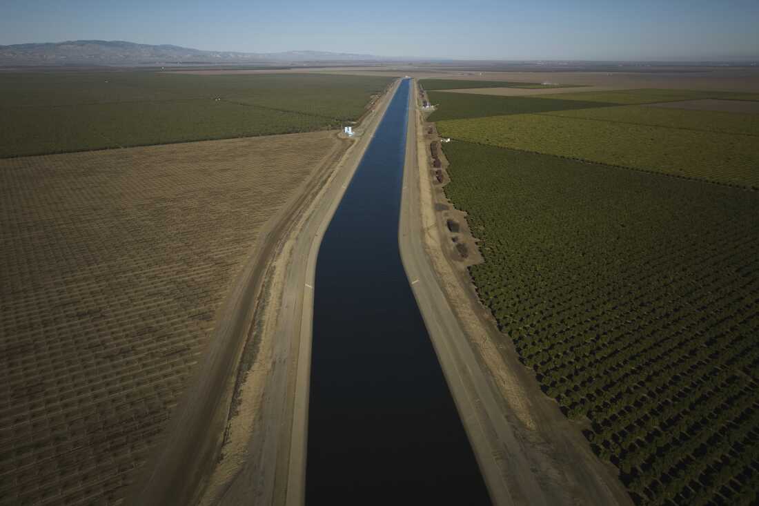 A canal cutting through farmland stretches into the distance.