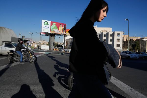 A woman crosses a square in Tehran, Iran, Thursday, Feb. 26, 2026. (AP Photo/Vahid Salemi)