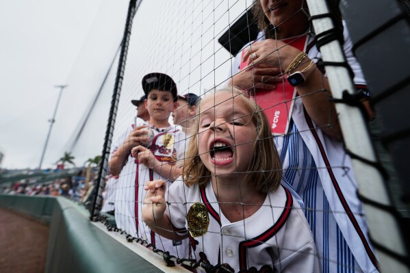 Lively Hagauer, of Atlanta, with permanent marker on her face, yells out for autographs before a spring training baseball game between the Atlanta Braves and the Minnesota Twins in North Port, Fla., Feb. 22, 2026. (AP Photo/Gerald Herbert, File)