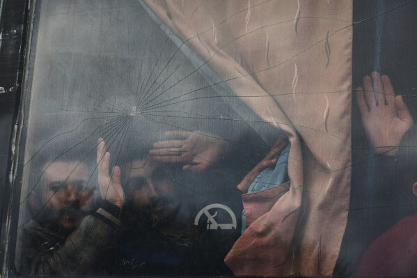 Syrian government prisoners wave from a bus after their release in a prisoner exchange between Syrian government forces and Druze militiamen in Sweida province, Syria, Feb. 26, 2026. (AP Photo/Ghaith Alsayed, File)