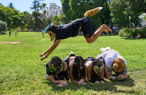 A youth jumps over other therians, people who say they identify as non-human animals, during a gathering in a square in Buenos Aires, Argentina, Feb. 22, 2026. (AP Photo/Rodrigo Abd, File)