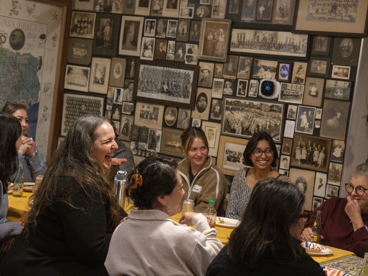 Members of Las Comadres Para Las Americas laugh during a potluck in Austin, Texas on Jan. 27. On this night the gathering takes place at the home of Lourdes Rodriguez — filled with art from the Americas, Asia and Africa. The mood is festive, warm, but also solemn, at times.