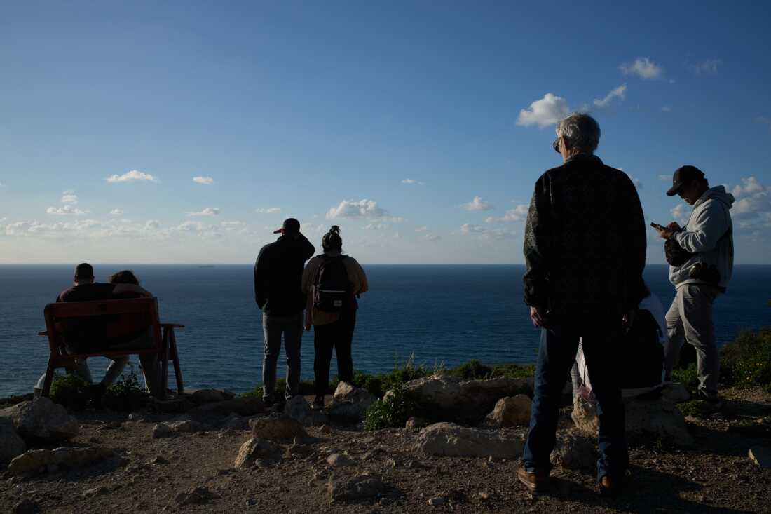 People gather at a lookout to look for the possible arrival of the US Navy's aircraft carrier USS Gerald R. Ford in the Mediterranean Sea near the coast of Haifa, northern Israel, Friday, Feb. 27, 2026.