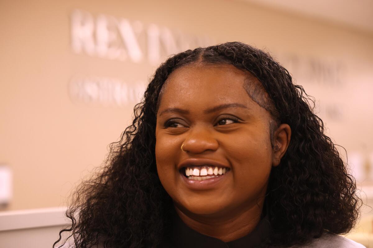 Dental student Somkene Okwuego smiles after completing work on patient Jimmy Stewart, 83, who receives affordable dental work