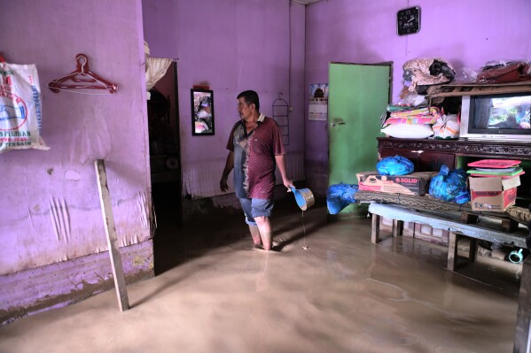 A man stands inside his flooded home in Pidie Jaya, Aceh province, Indonesia, Wednesday, Dec. 3, 2025. (AP Photo/Reza Saifullah)