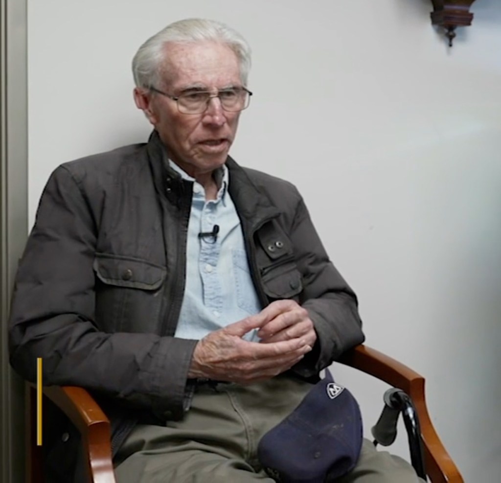 Irving Rosenberg, a 90-year-old man, sitting and speaking with his hands clasped.