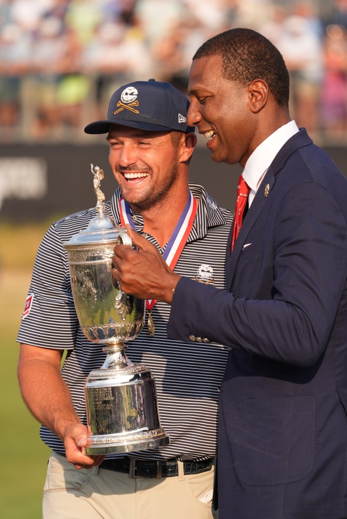 Bryson DeChambeau celebrates with the trophy and USGA president Fred Perpall after winning the U.S. Open.