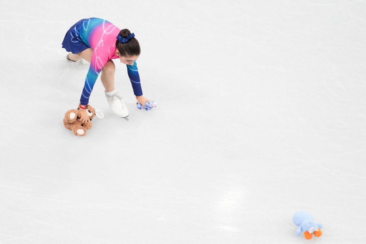 An Olympic flower girl picks up stuffed animals after a skater's performance on February 13. Fans <a href=