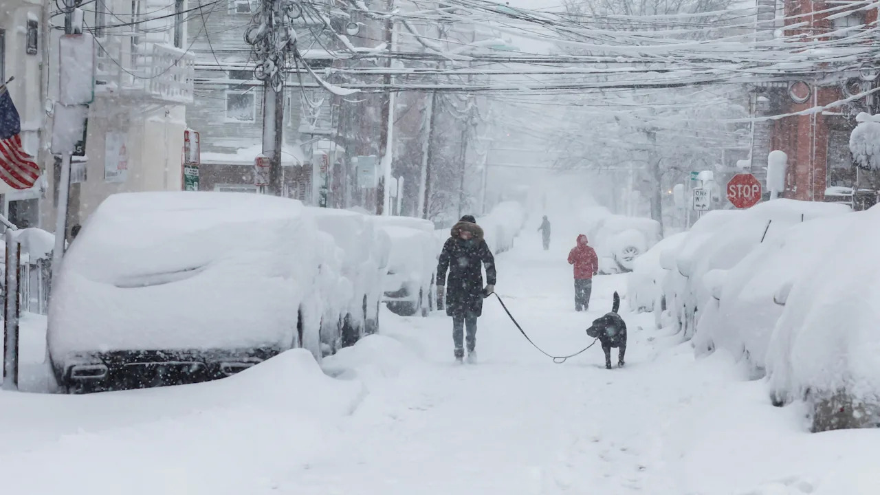 People walk on a local street covered with snow during a winter storm in Hoboken, N.J., on Feb 23.