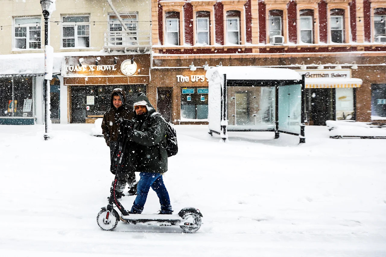 People walk on a local street covered with snow during a winter storm in Hoboken, N.J., on Feb. 23.