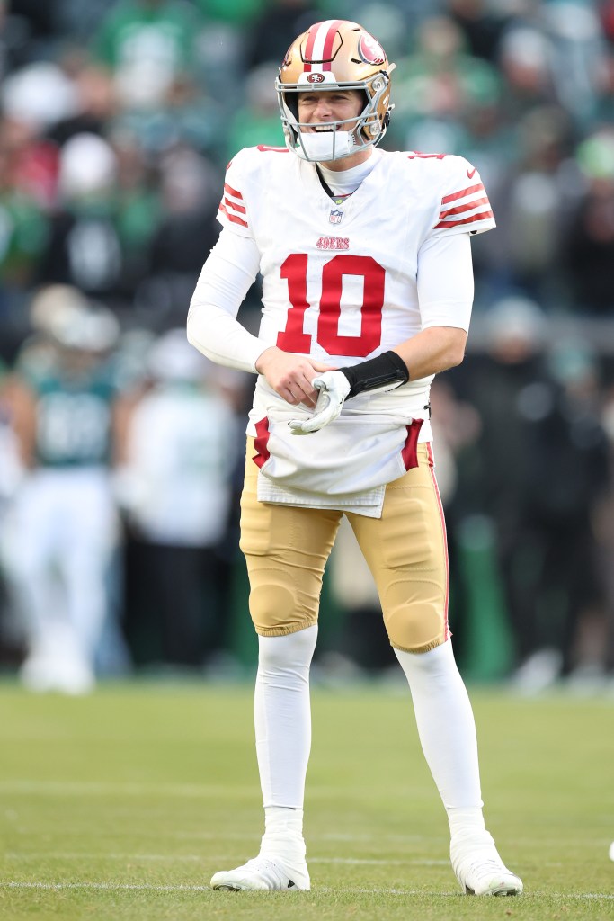 San Francisco 49ers player Mac Jones warms up on the field.