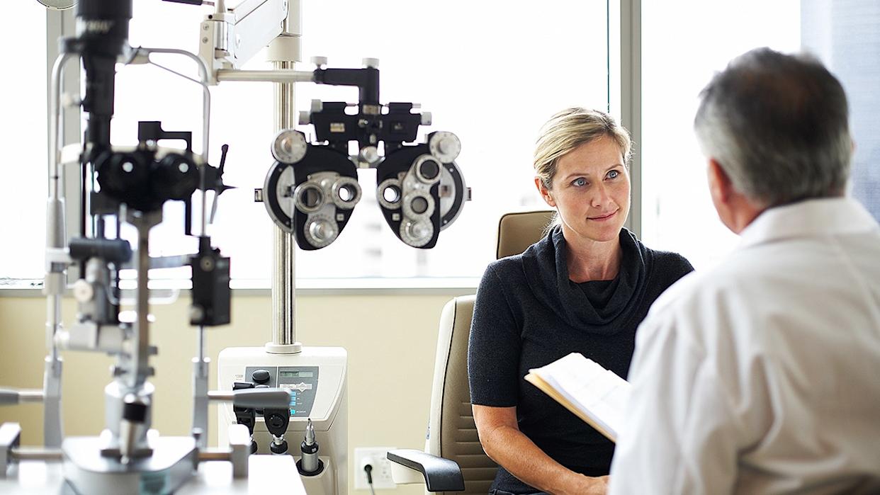 woman sits and listens as eye doctor speaks