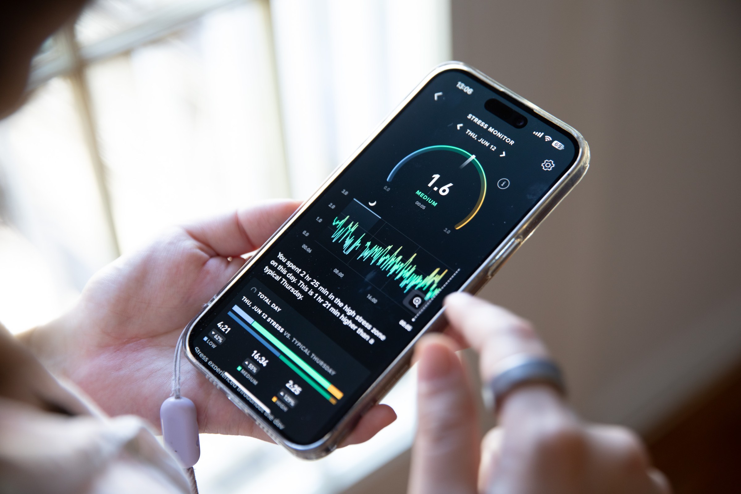 Close up of a person looking at a stress monitor feature in the Whoop app on an iPhone. 