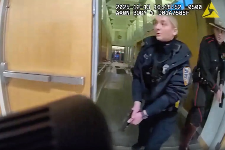 Two police officers walk through a doorway in a school hallway