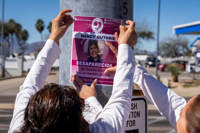 A person puts up a poster.