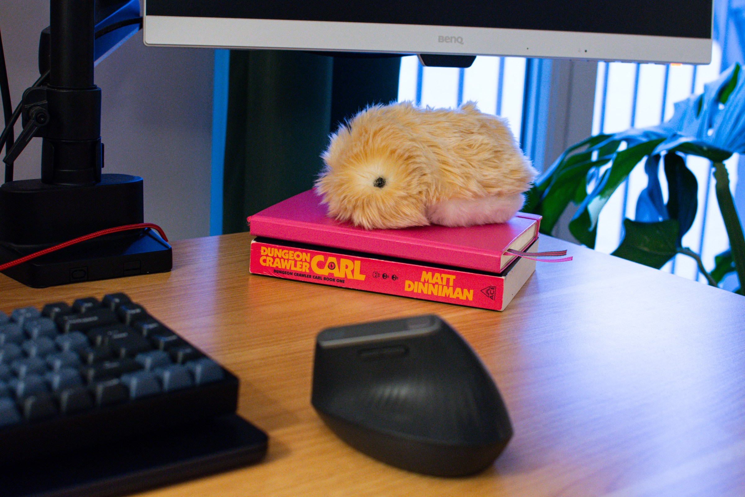 Moflin on a pile of books on a desk.