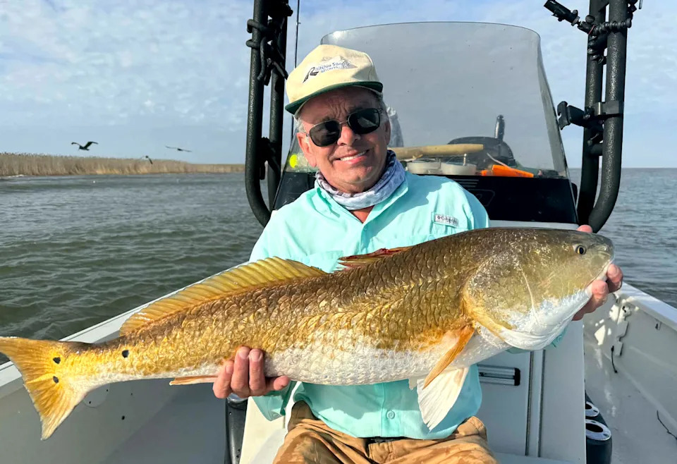 A fisherman with a big Louisiana redfish.