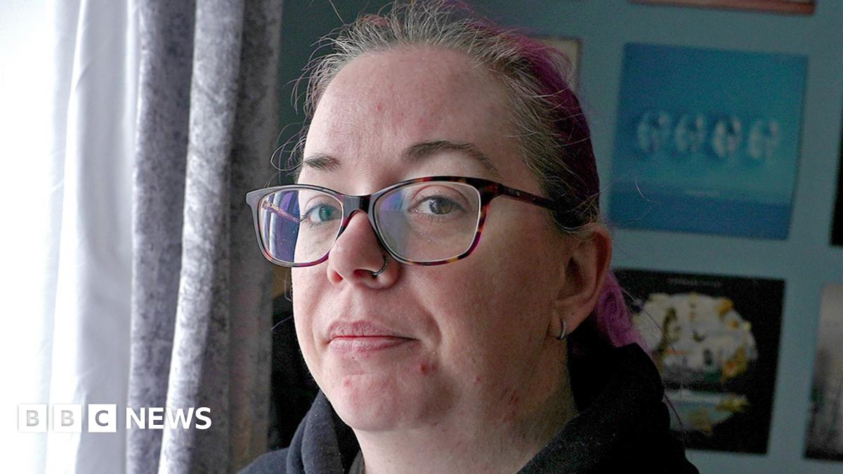 Emma wears glasses and a black hoodie.