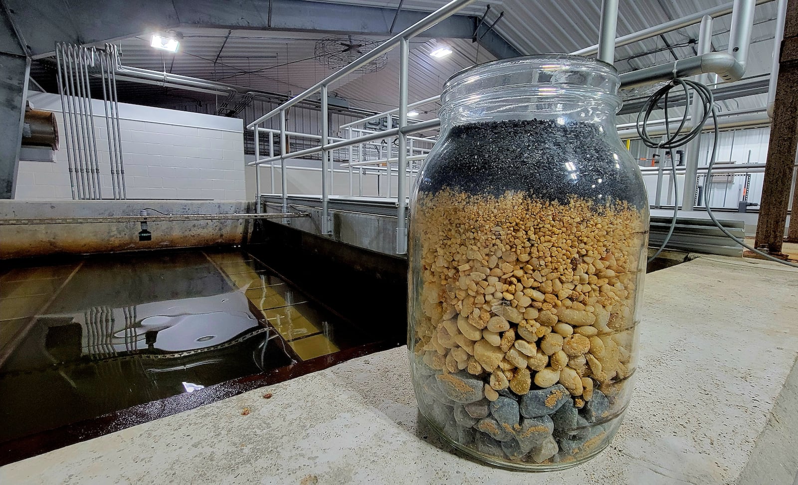 This jar contains a cross section of the medium used to filter and soften residents' drinking water at the Yellow Springs water treatment plant, Feb. 6, 2026. Yellow Springs' water rates are the most expensive in the Miami Valley, according to the annual PIqua Water Rate Study. LONDON BISHOP/STAFF