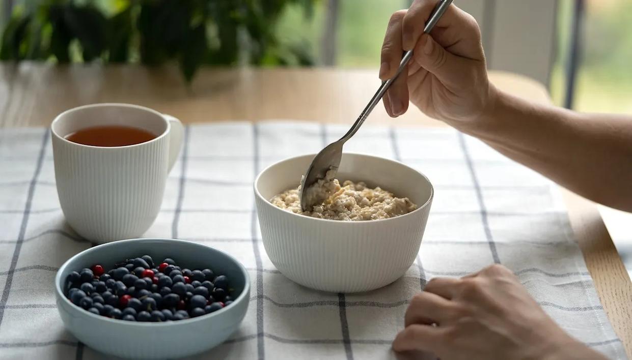 Woman at table eating oatmeal