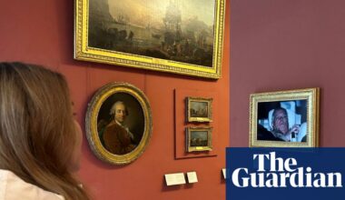 Activists hang photo of Andrew leaving police custody in the Louvre | UK news
