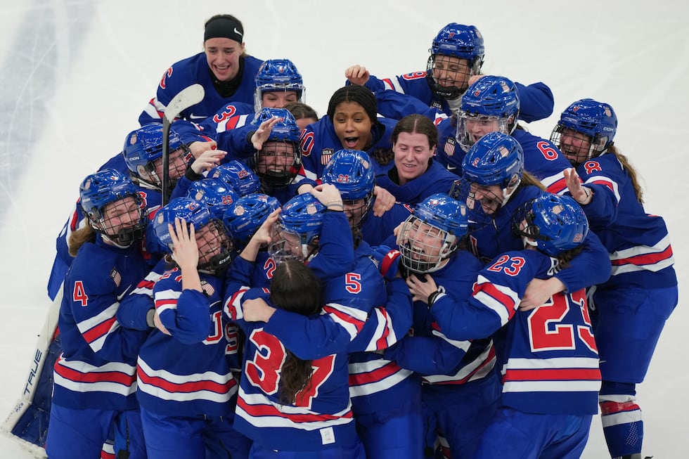 United States players celebrate after beating Canada in overtime to win the women's ice hockey...